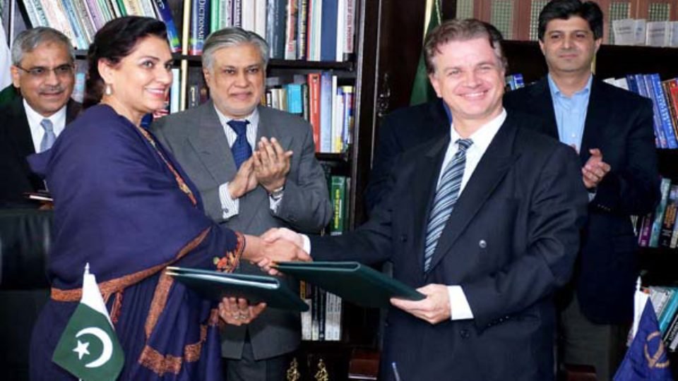 Anjum Assad Amin and Werner E. Liepach exchanging documents after signing loan agreementAPP