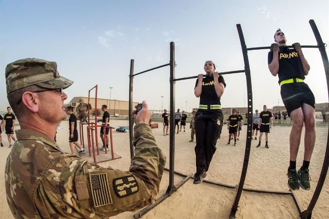 Soldiers participate in the flexed arm-hang during qualifications for the German Armed Forces Badge for Military Proficiency at Camp Arifjan, Kuwait, April 28, 2017