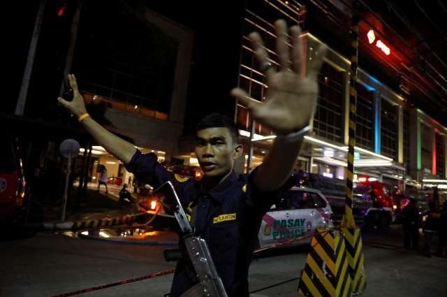 A security guard stops photographers from entering the vicinity of Resorts World Manila Pic Reuters
