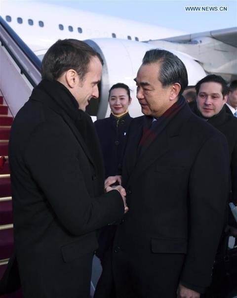 French President Emmanuel Macron is welcomed by Chinese Foreign Minister Wang Yi upon his arrival in Beijing